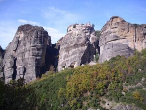 Santuario incastonato nella roccia, affacciato su una valle, simbolo di pace e bellezza naturale.