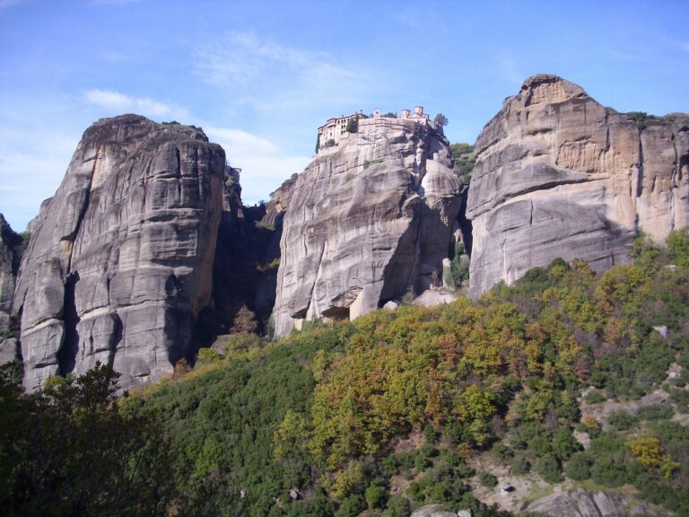 Santuario incastonato nella roccia, affacciato su una valle, simbolo di pace e bellezza naturale.