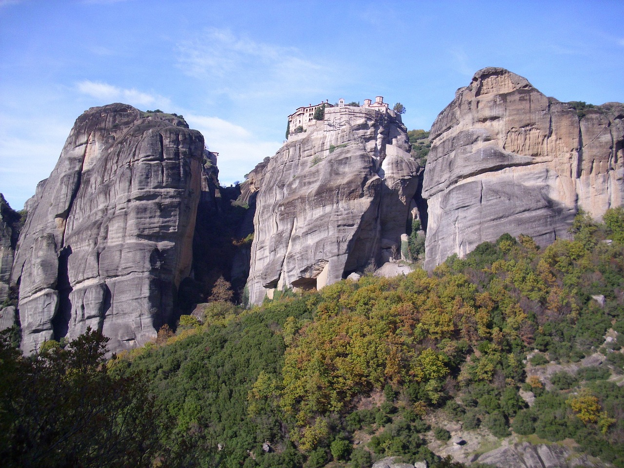 Santuario incastonato nella roccia, affacciato su una valle, simbolo di pace e bellezza naturale.