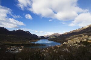 Lago di Scanno a forma di cuore con donne in costume tradizionale che passeggiano lungo le sue rive.