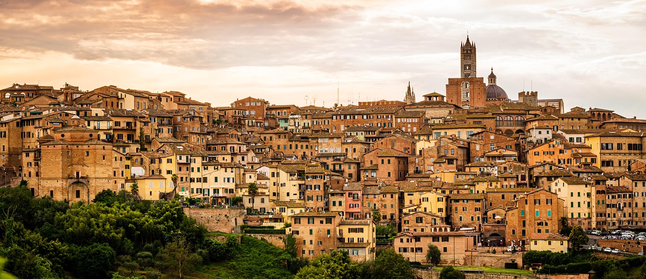 Borgo di Pitigliano al tramonto, con edifici di tufo che brillano di luce dorata.